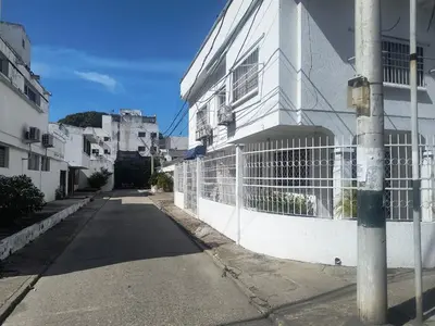 a white building with a fence next to a street at Tranquila y cerca de la magia in Cartagena de Indias