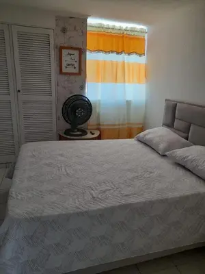 a bedroom with a large bed with a window at Habitacion en el Norte cerca al Malecón in Barranquilla