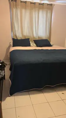a bed with black sheets and pillows in a room at Habitacion en el Norte cerca al Malecón in Barranquilla