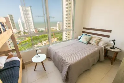 a bedroom with a bed and a large window at Apartamento Oasis Cartagena in Cartagena de Indias