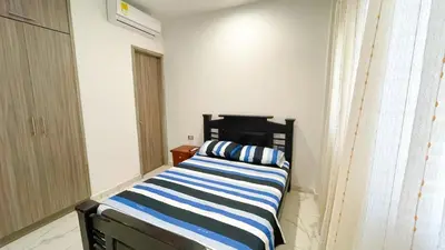 a bedroom with a bed with a blue and white stripes at Casa Elena in Tolú