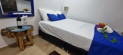 a bedroom with a bed and a table with a bottle of wine at Cabaña Mary Mar en Isla in Cartagena in Isla de Tierra Bomba