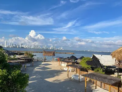 a beach with tables and chairs and a city at Cabaña Mary Mar en Isla in Cartagena in Isla de Tierra Bomba