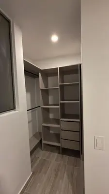 a walk in closet with shelves and a window at Margarita's apt in Barranquilla