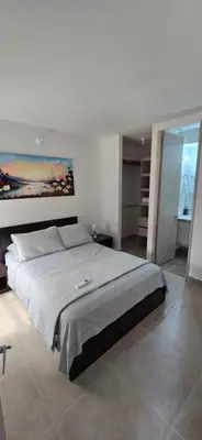 a bedroom with a large bed with a painting on the wall at SERENA REST Conjunto Capriella Cartagena in Manzanillo del Mar