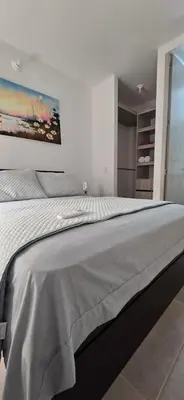 a bedroom with a large bed with a painting on the wall at SERENA REST Conjunto Capriella Cartagena in Manzanillo del Mar