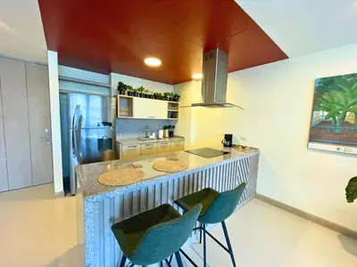 a kitchen with a counter with chairs and a refrigerator at Apto Con Ubicación Privilegiada in Barranquilla