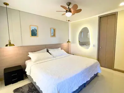 a bedroom with a white bed and a ceiling fan at Apto Con Ubicación Privilegiada in Barranquilla