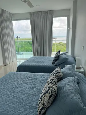 two beds in a bedroom with a large window at Morros 922 Seaside Retreat in Cartagena de Indias
