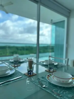 a table with plates and utensils on a glass table at Morros 922 Seaside Retreat in Cartagena de Indias