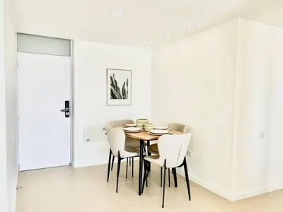 a dining room with white walls and a table and chairs at Splendid condo with a sea view in Puerto Colombia