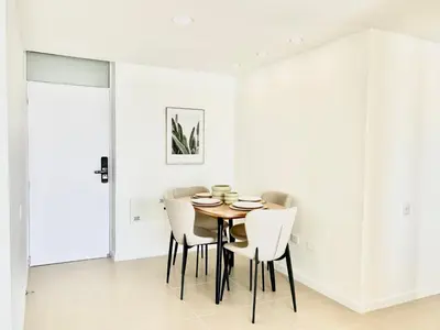 a dining room with white walls and a table and chairs at Splendid condo with a sea view in Puerto Colombia