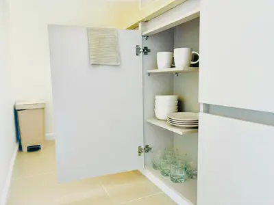 a kitchen with a white door and plates on shelves at Splendid condo with a sea view in Puerto Colombia