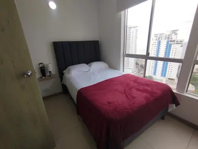 a bedroom with a bed with a red blanket and a window at Apartamento Cartagena exclusive in Cartagena de Indias