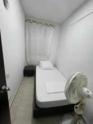 a small room with a bed and a fan at ruiseñor 1 in Barranquilla