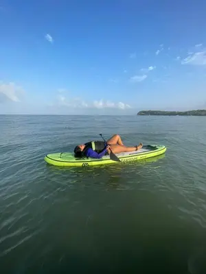a person laying on a paddle board in the water at Ikako beach club in Cartagena de Indias