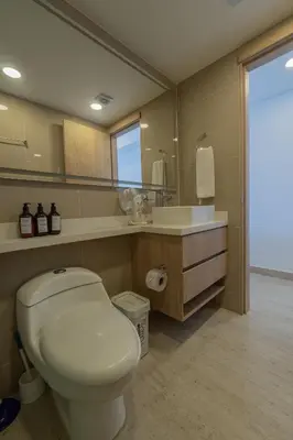a bathroom with a toilet and a sink and a mirror at Suite 15th floor con vista mar y piscina CB1511 in Cartagena de Indias