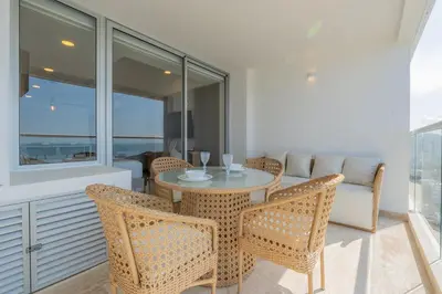 a dining room with a table and chairs and a couch at Suite 15th floor con vista mar y piscina CB1511 in Cartagena de Indias