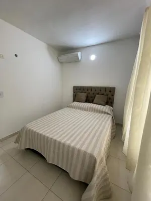 a small bedroom with a bed with a striped blanket at Brisas del caribe in Cartagena de Indias