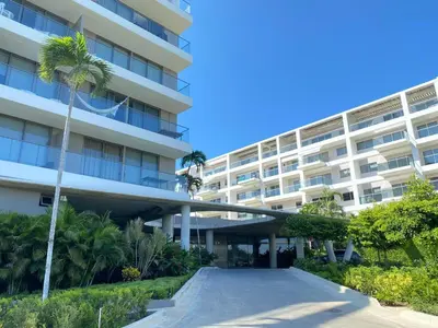 an apartment building with a palm tree in front of it at Apartamento en Playa Manzanillo in Cartagena de Indias