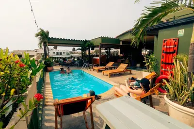 a group of people sitting in chairs by a swimming pool at Viajero Cartagena - Getsemaní Hostel in Cartagena de Indias