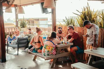 a group of people sitting at a table on a patio at Viajero Cartagena - Getsemaní Hostel in Cartagena de Indias