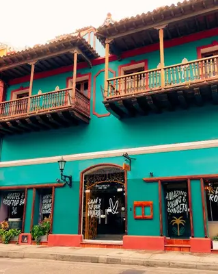 a green building with two balconies on top of it at Viajero Cartagena - Getsemaní Hostel in Cartagena de Indias