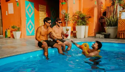 three men are sitting in a swimming pool at Viajero Cartagena - Getsemaní Hostel in Cartagena de Indias