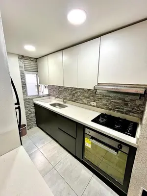 a kitchen with white cabinets and a sink at Luxury loft with pool in Barranquilla