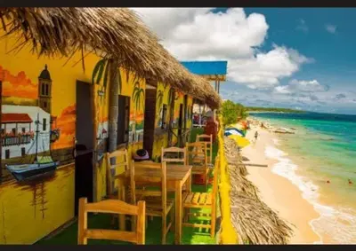 a restaurant with tables and chairs on the beach at TESORO de BARU in Cartagena de Indias
