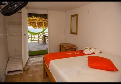 a bedroom with a bed and a door to a patio at TESORO de BARU in Cartagena de Indias