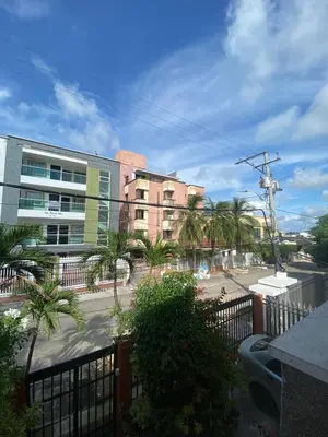a view of a street with palm trees and a building at Encanto Barranquillero! in Barranquilla