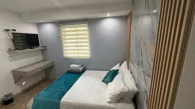 a small bedroom with a bed and a window at Apartamentos Crespo 67 aeropuerto in Cartagena de Indias