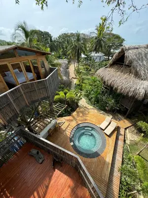 an outdoor hot tub on a deck next to a house at COCO SALVAJE Tree House in La Rada