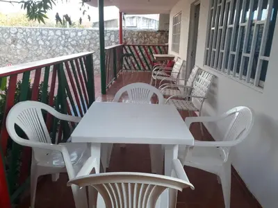 a white table and chairs on a balcony at Cabaña Puerto Colombia CARNAVAL BARRANQUILLA 2025 in Puerto Colombia