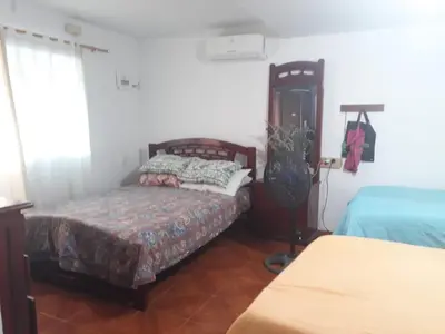 a bedroom with a bed and a guitar in it at Cabaña Puerto Colombia CARNAVAL BARRANQUILLA 2025 in Puerto Colombia