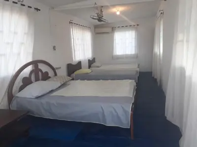a room with three beds and two windows at Cabaña Puerto Colombia CARNAVAL BARRANQUILLA 2025 in Puerto Colombia