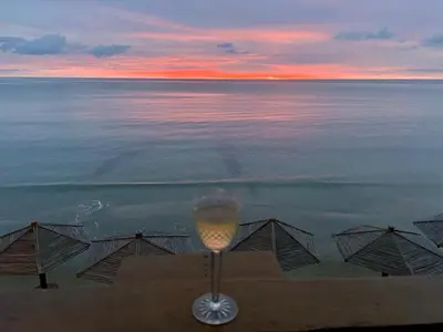 a glass of wine on the beach at sunset at Un paraíso frente al mar in San Silvestre