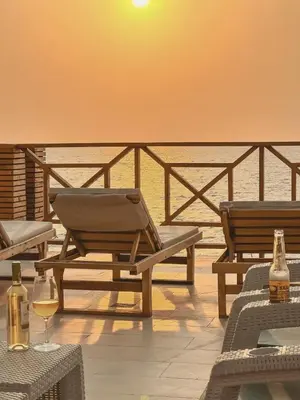 a patio with two chairs and a table with wine glasses at Un paraíso frente al mar in San Silvestre