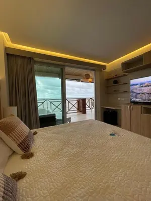 a bedroom with a large bed with a view of the ocean at Un paraíso frente al mar in San Silvestre