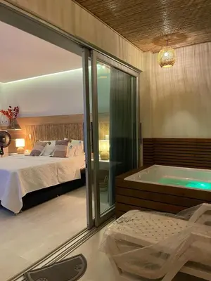a bedroom with a bed and a tub in a room at Un paraíso frente al mar in San Silvestre