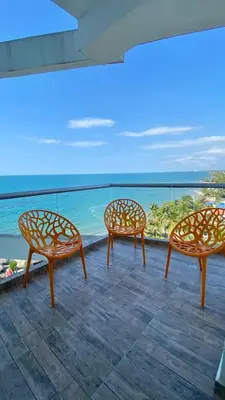 three chairs sitting on a balcony looking out at the ocean at Fontainebleu in Coveñas