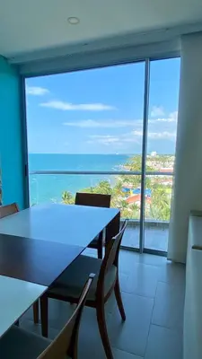 a dining room with a table and a view of the ocean at Fontainebleu in Coveñas
