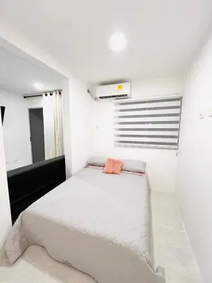 a white bedroom with a bed and a window at Cozy Beachside 3BR Apartment near the Walled City in Cartagena de Indias