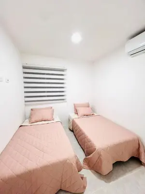 two beds in a room with pink beds at Cozy Beachside 3BR Apartment near the Walled City in Cartagena de Indias