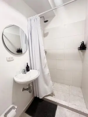 a white bathroom with a sink and a mirror at Cozy Beachside 3BR Apartment near the Walled City in Cartagena de Indias