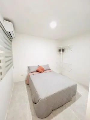 a bedroom with a bed in a white room at Cozy Beachside 3BR Apartment near the Walled City in Cartagena de Indias