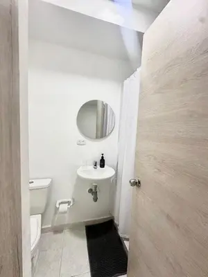 a white bathroom with a sink and a mirror at Cozy Beachside 3BR Apartment near the Walled City in Cartagena de Indias