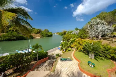 a view of a river with palm trees and a pathway at Maravillosa Villa en Marina Baru enCartagena! in Isla Barú