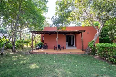 a small red house with a porch and chairs at Maravillosa Villa en Marina Baru enCartagena! in Isla Barú
